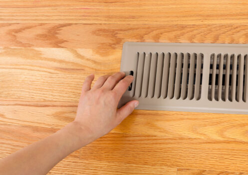 Woman checking the vent for warm air
